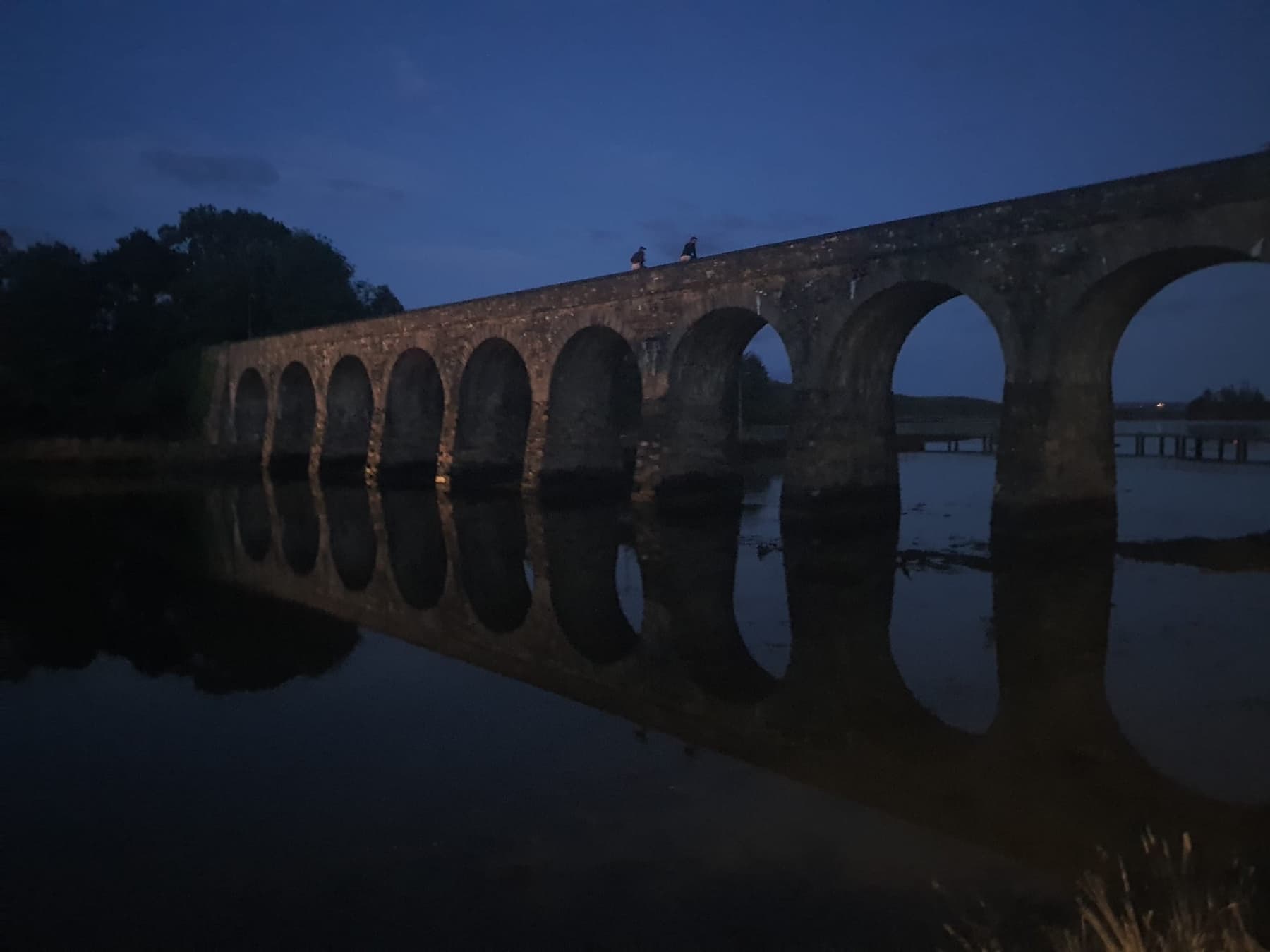 Ballydehob’s stone railway bridge reflected in the water at dusk